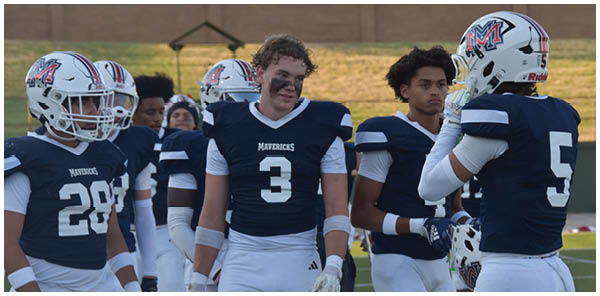 A group of football players on a field. Description generated by AI