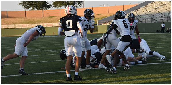A group of football players on a field. Description generated by AI