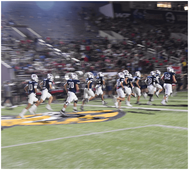 A group of football players on a field. Description generated by AI