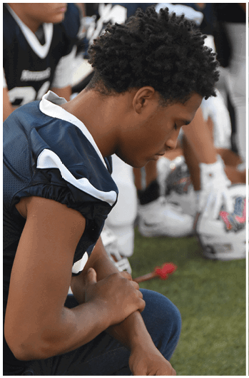 A group of football players on a field. Description generated by AI