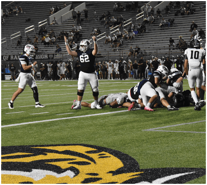 A group of football players on a field. Description generated by AI