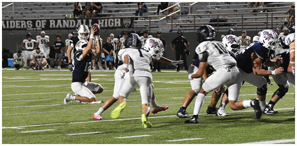 A group of football players on a field. Description generated by AI