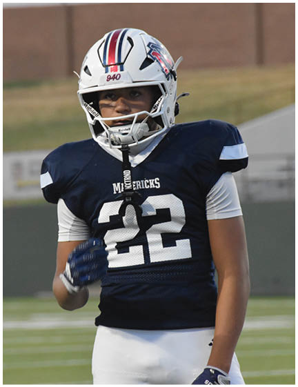 A football player wearing a blue and red jersey. Description generated by AI