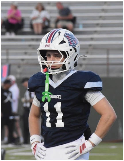 A football player wearing a blue and red jersey. Description generated by AI
