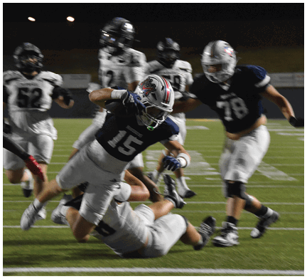A football game is taking place with a group of men on the field. Description generated by AI