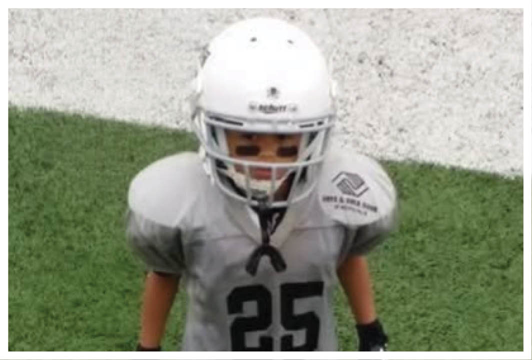 A football player wearing a blue and red jersey. Description generated by AI