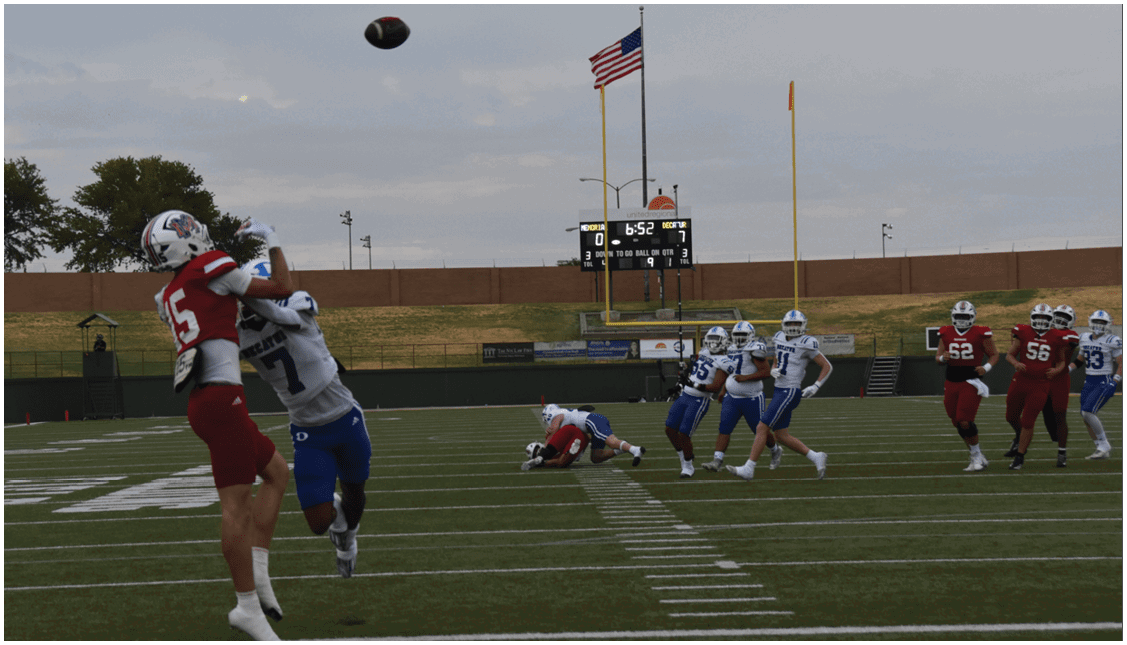 A group of football players on a field. Description generated by AI