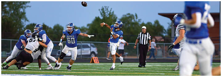 A football player in a blue jersey throws a football. Description generated by AI
