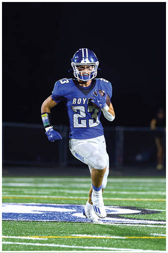 A football player running on the field. Description generated by AI