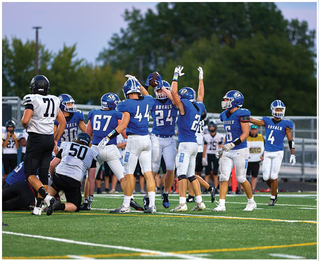 A group of football players celebrating on the field. Description generated by AI