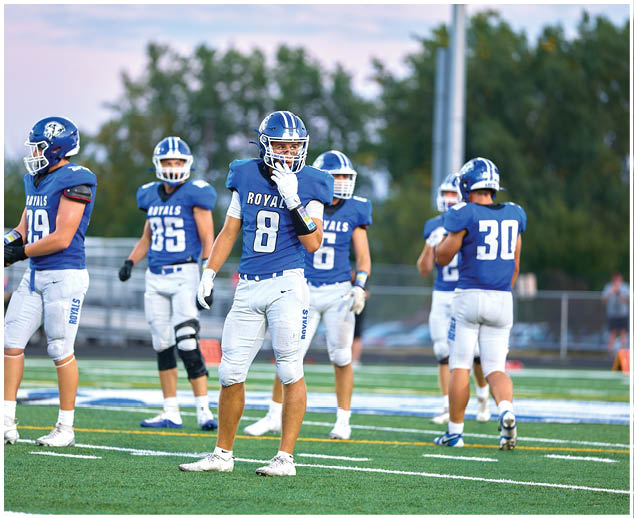 A group of football players wearing blue and white uniforms. Description generated by AI