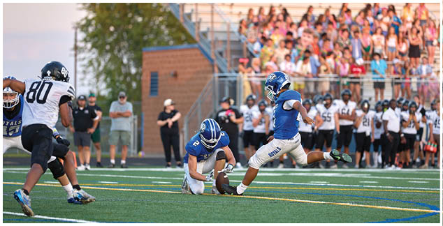 A football player is kicking a ball on a field. Description generated by AI