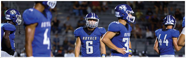 A group of football players wearing blue and white uniforms. Description generated by AI