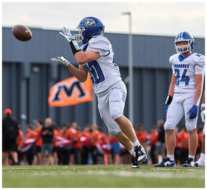A football player catching a ball. Description generated by AI
