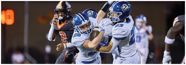 A football player is tackled to the ground. Description generated by AI