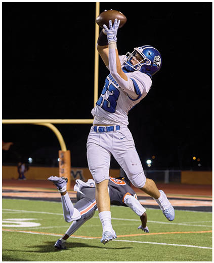 A football player catching a ball. Description generated by AI
