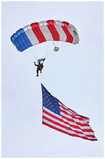 A person is parasailing with an American flag. Description generated by AI