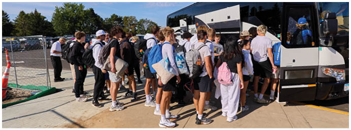 A group of people are standing in front of a bus. Description generated by AI
