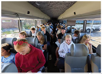 A group of people sitting on a bus. Description generated by AI