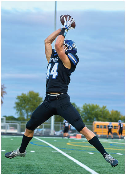 Two football players running on a field. Description generated by AI