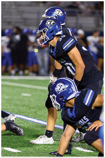 Two football players on a field. Description generated by AI