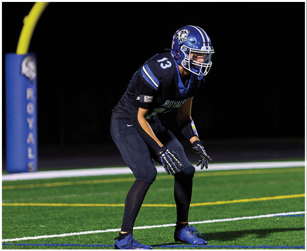 A group of football players wearing blue and white uniforms. Description generated by AI