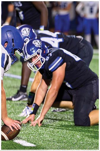 Two football players on a field. Description generated by AI