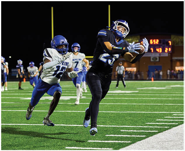 A group of football players wearing blue and white uniforms. Description generated by AI