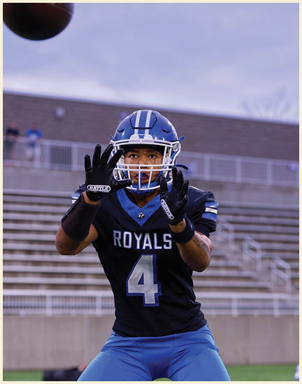 A football player wearing a black jersey with the number 11 on it. Description generated by AI