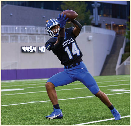 A football player is kicking a football on a field. Description generated by AI
