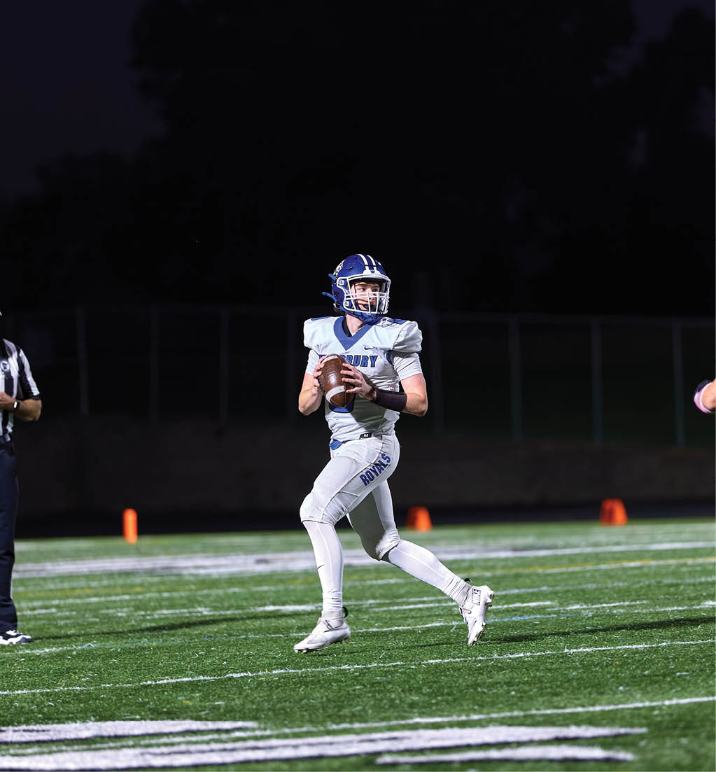 A football player running with a football. Description generated by AI