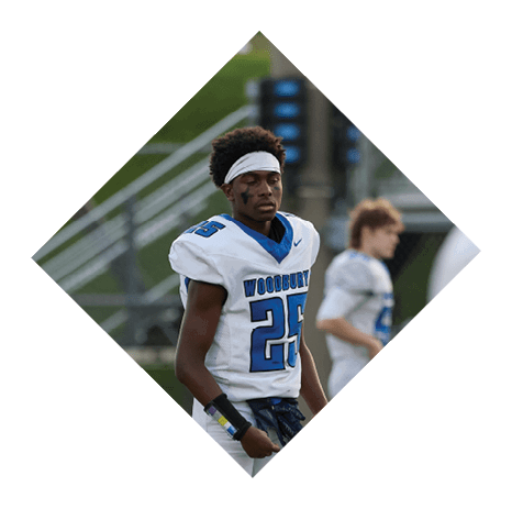 A football player wearing a black jersey with the number 3 kneels on the field. AI generated content