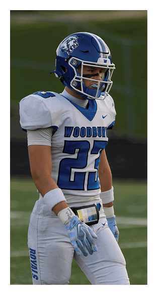 A football player is kneeling on the field, wearing a green jersey and a helmet. AI generated content