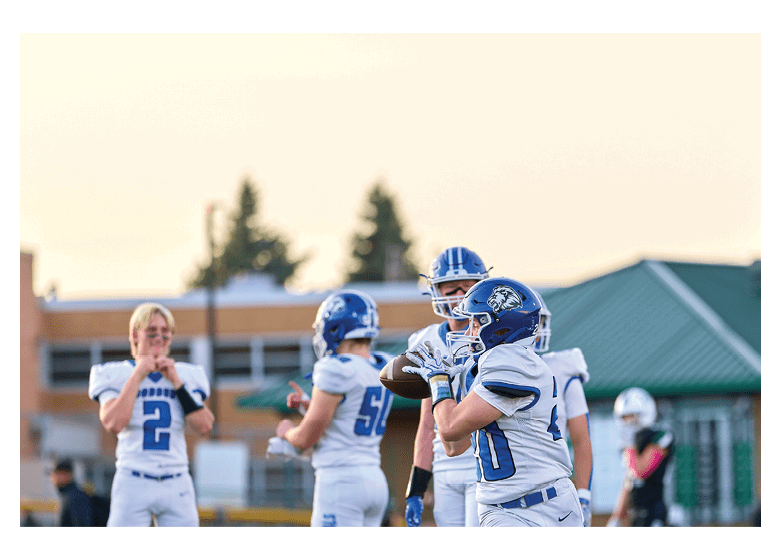 A group of football players on a field, one of them is running with a football. AI generated content