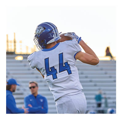 A football player in a white jersey with the number 85 on it is trying to catch a football. AI generated content