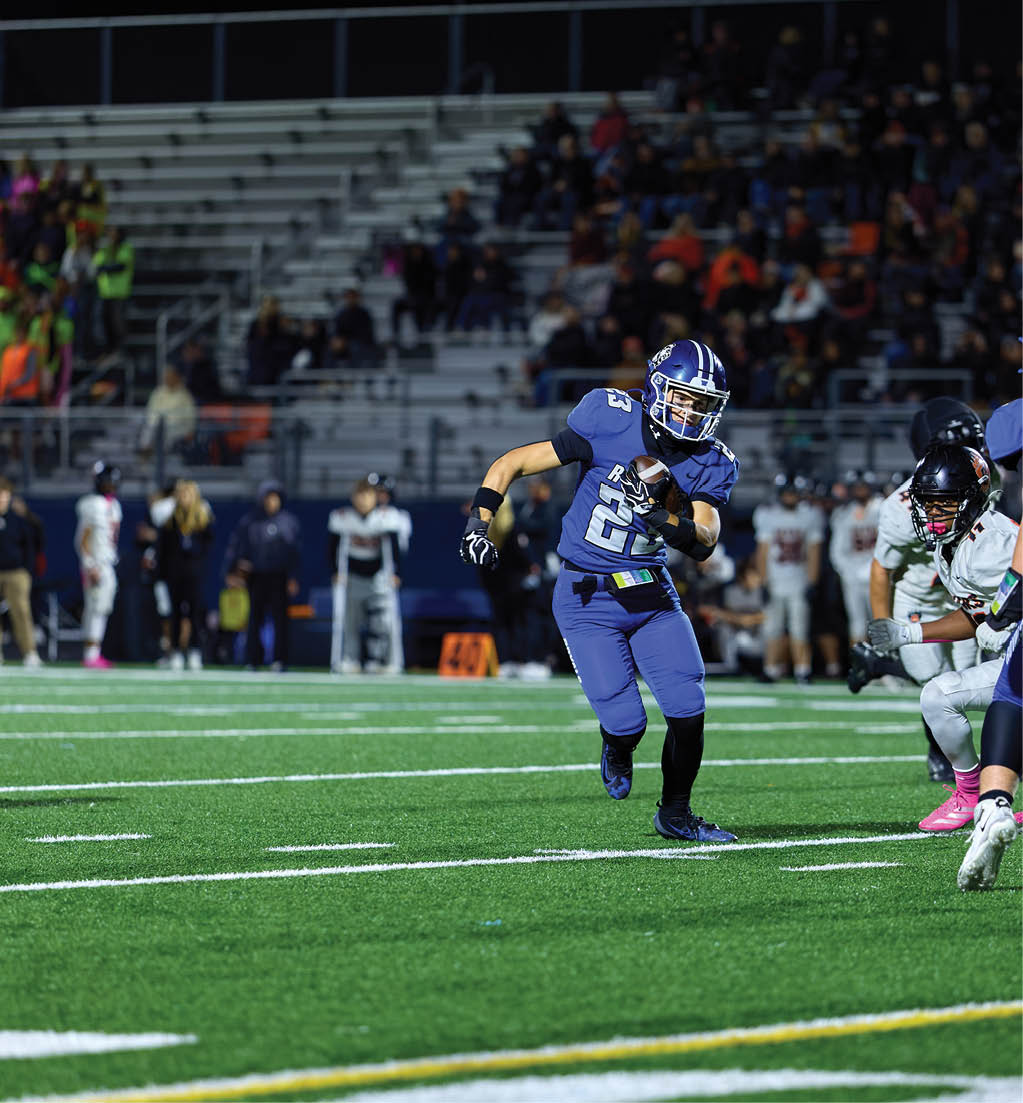 A football player running with a football. Description generated by AI