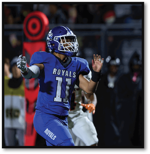 A football player wearing a black jersey with the number 6 on it. Description generated by AI
