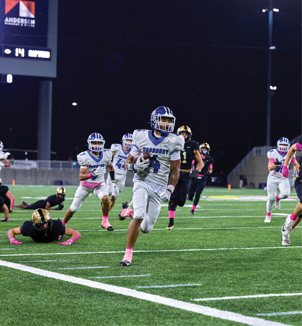 A football player running with a football. Description generated by AI