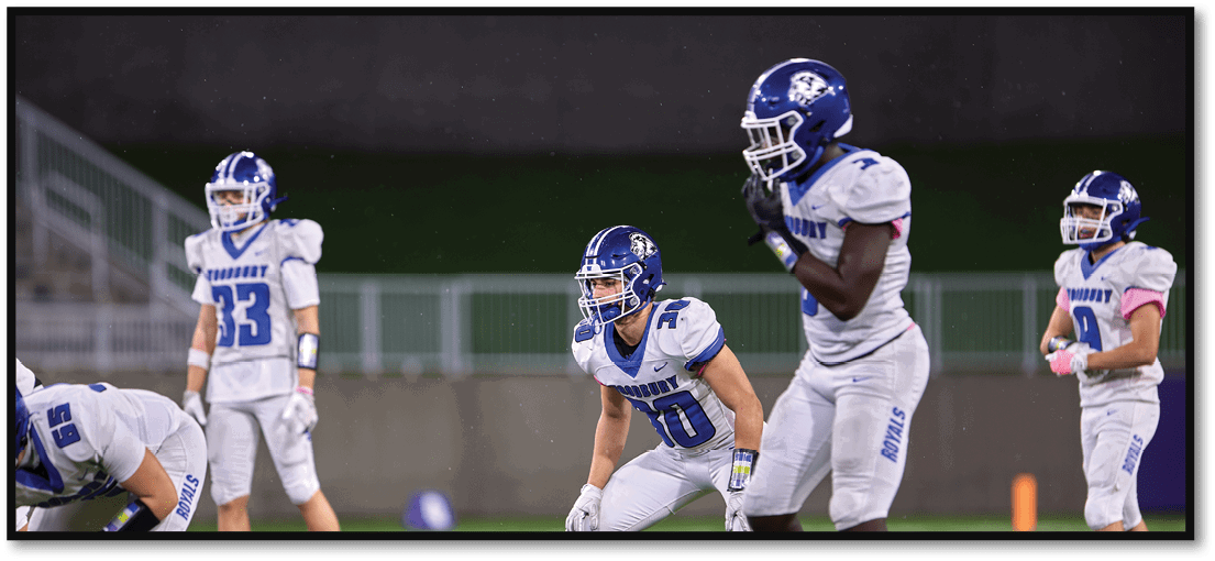 A group of football players on a field. Description generated by AI