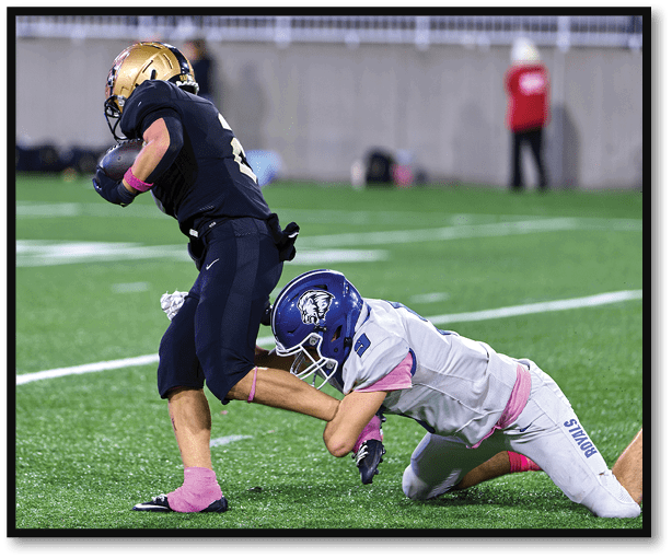 A football player is kicking a football on a field. Description generated by AI