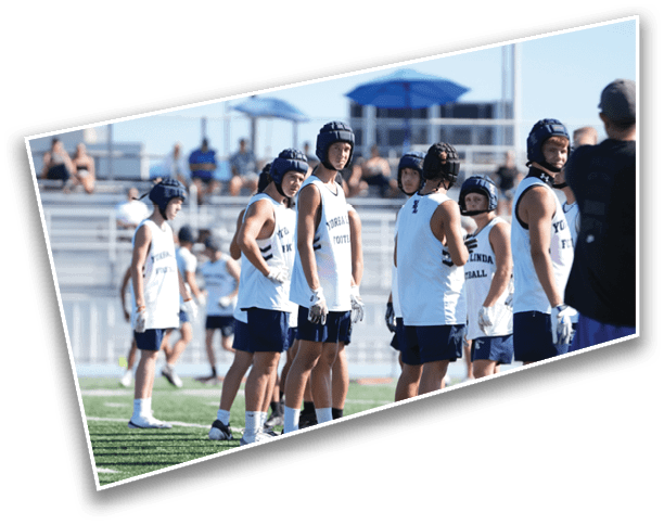 A group of people wearing sports helmets and athletic clothing stand on a field, appearing to prepare for a game or practice. Description generated by AI
