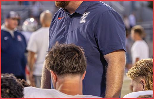 Several people wearing white sports jerseys are gathered closely together, with one person’s face partially visible in the center. Description generated by AI