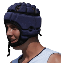 A person wearing a white sleeveless sports jersey with “TURBA LINDA FOOTBALL" printed on it and a padded protective helmet is standing outdoors. Description generated by AI