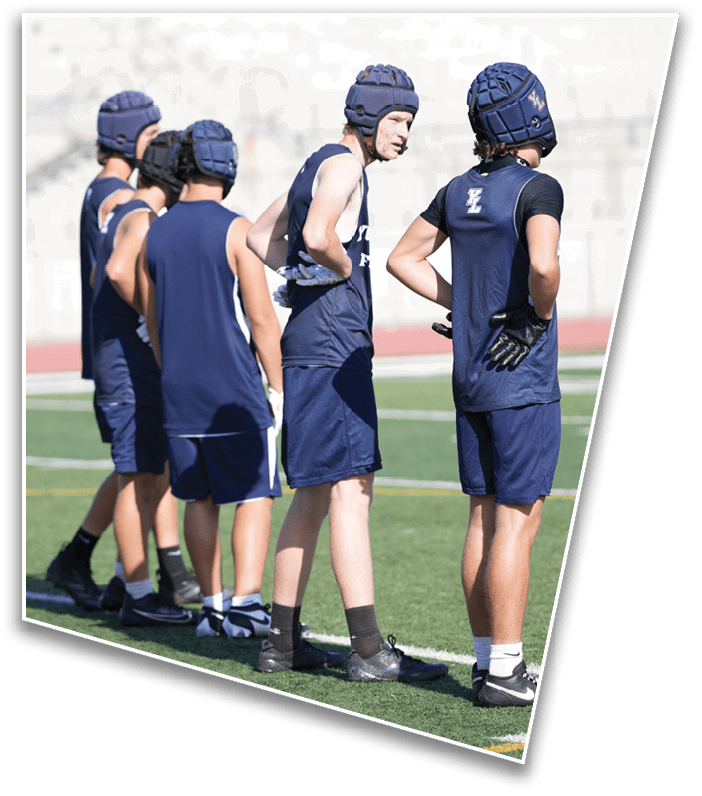 Several people wearing athletic shorts and shoes are standing in a line on a sports field with artificial turf. Description generated by AI
