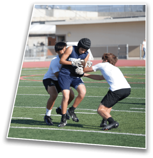 Three people wearing athletic clothing are engaged in a physical activity on a green sports field with white yard lines. Description generated by AI