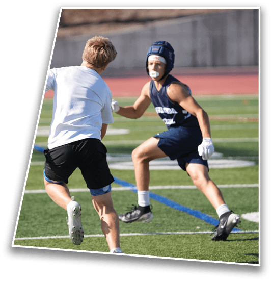 A person wearing athletic gear and a helmet is running on a sports field marked with yard lines. Description generated by AI