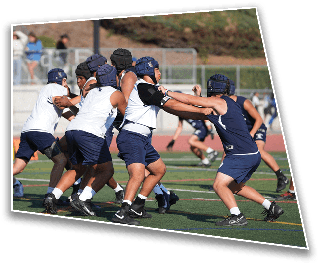 A group of people wearing helmets and athletic clothing are engaged in a contact sport on a field. Description generated by AI