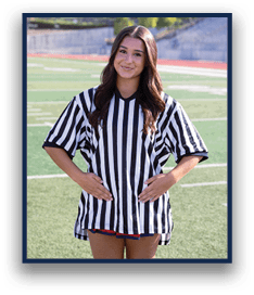 A person with long hair wearing a black and white striped referee shirt stands on a sports field with hands resting on their stomach. Description generated by AI