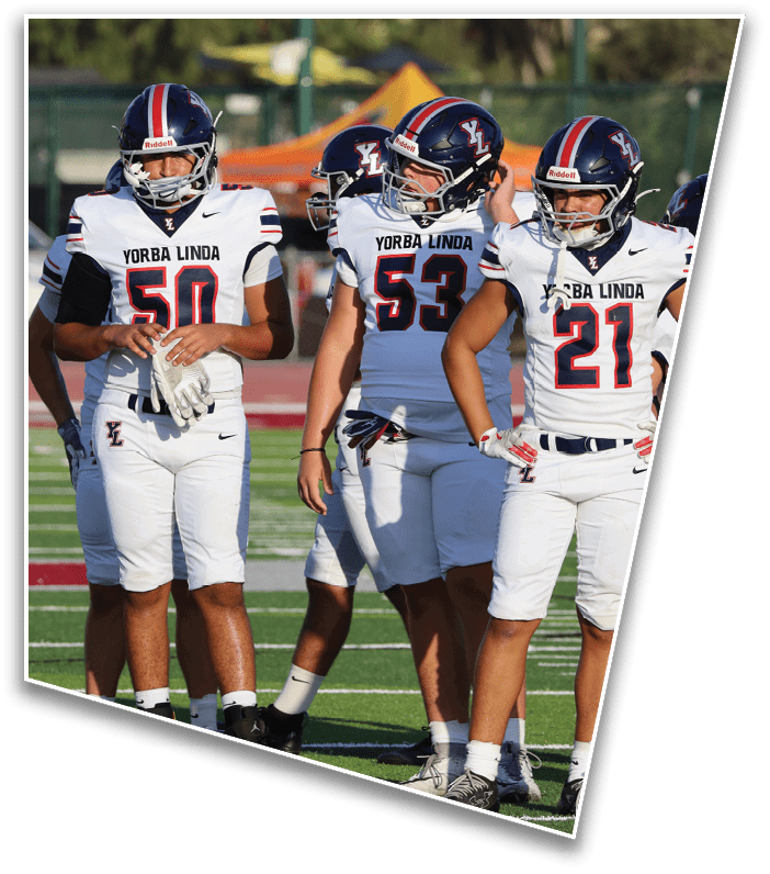 Four people wearing white football uniforms with “Yorba Linda" on the jerseys stand on a green field during a game or practice. Description generated by AI