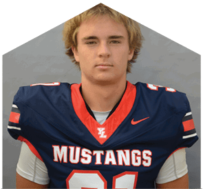 A person with short, light-colored hair is wearing a navy blue football jersey with red and white accents that says Mustangs and the number 21. Description generated by AI